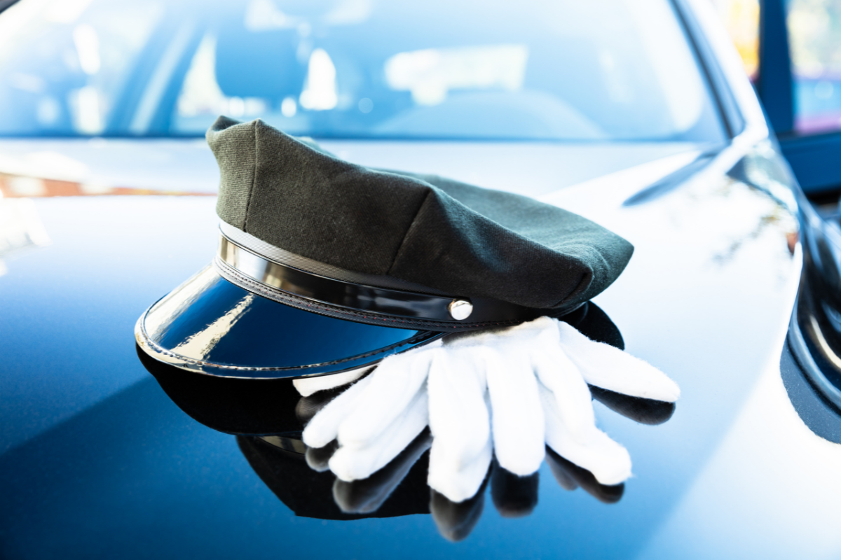 Chauffeurs hat and glove on the bonnet of their vehicle